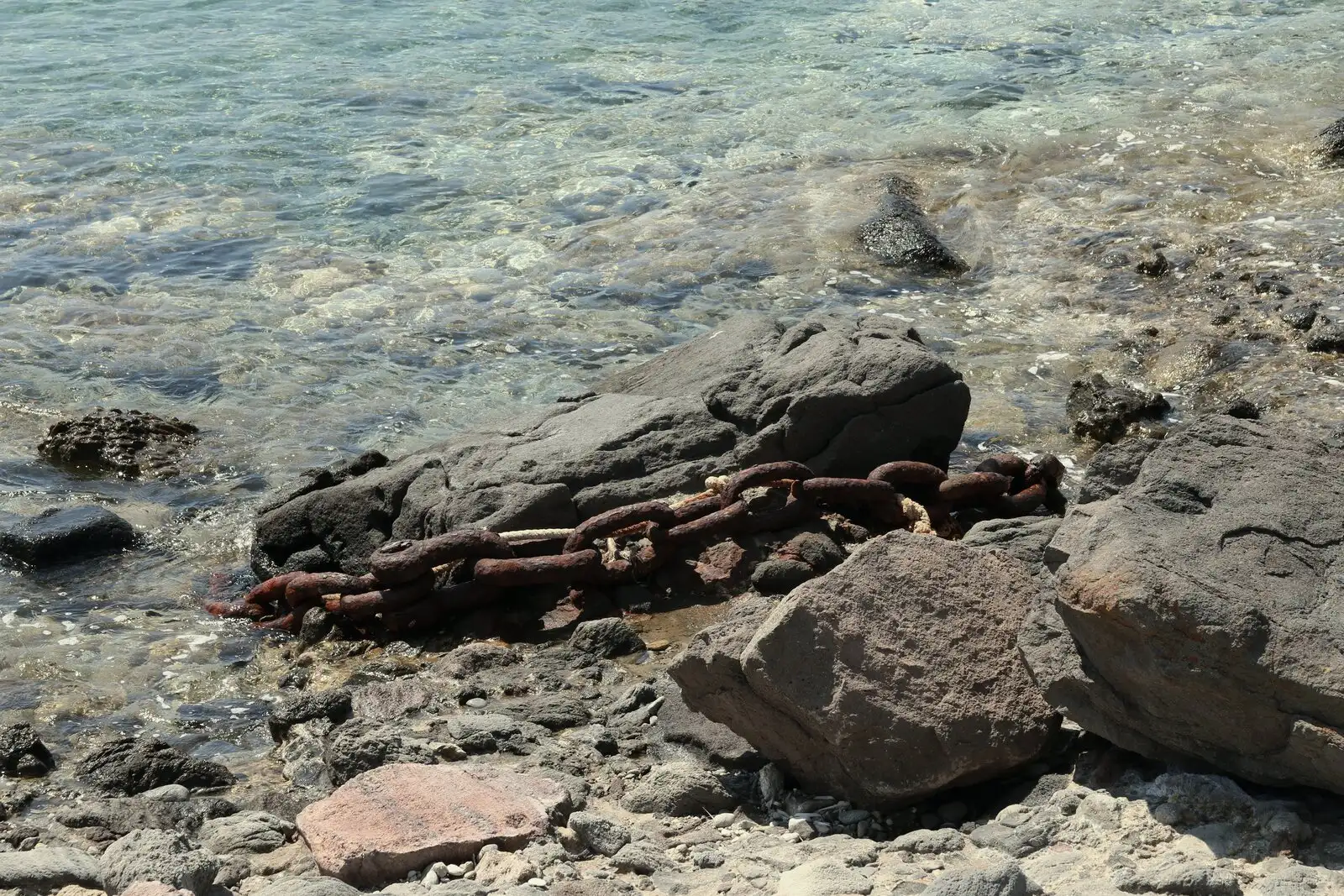 Μια παλιά αλυσίδα πάνω στα βράχια, στα ρηχά της Πολλώνιας